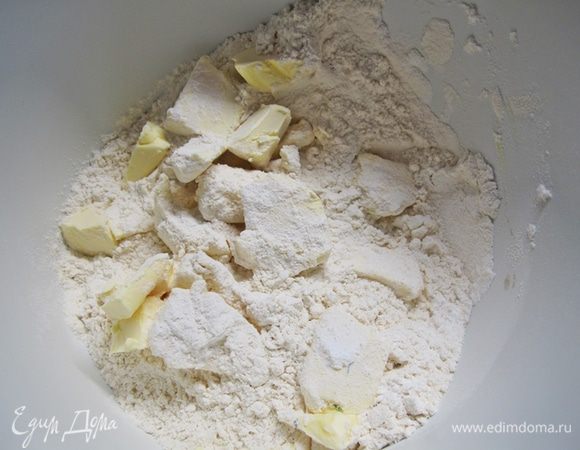 Масло перетереть с мукой и сахарной пудрой в крошку в крошку.
В отдельной посуде смешать желток и 45 мл ледяной воды.
