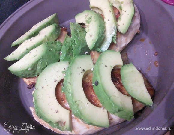 Затем выложить филе в форму для запекания, покрыть мясо пластинками авокадо.