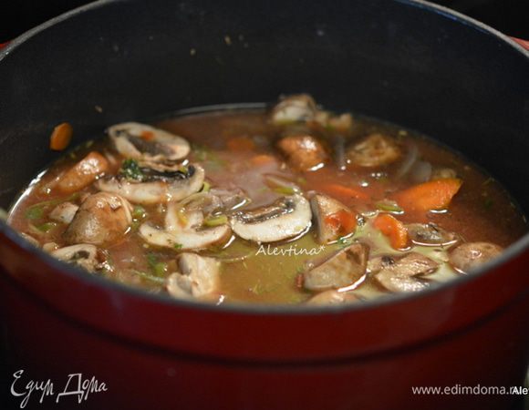 Влить вино, бульон, томатную пасту, лавровый лист. Вернуть говядину. Перемешать, посолить. Закрыть крышкой, убавить огонь и тушить примерно 1 час. За 10-15 минут добавить перловку быстрого приготовления. Закрыть крышкой и готовить 10-15 минут.