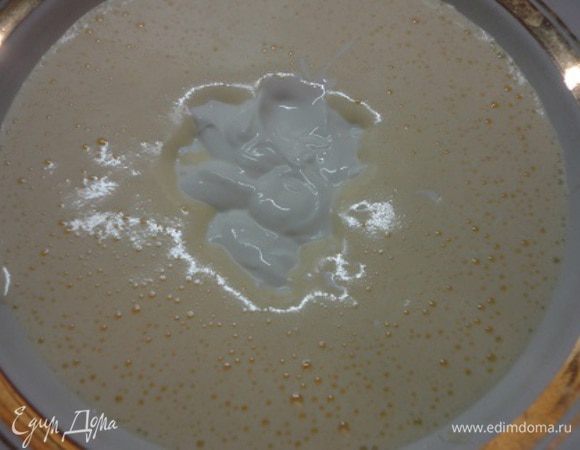 Добавить сметану, сгущенное молоко, соду, гашеную лимонным соком. Перемешать.