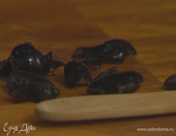 Оливки разрезать пополам и удалить косточки.