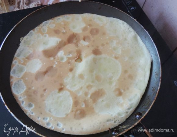 Выливаем на сковороду немного теста и, проворачивая ее на весу, распределяем равномерно по дну. Жарим около минуты с каждой стороны на высоком огне. Переворачивать блины лично мне удобно с помощью лопатки.