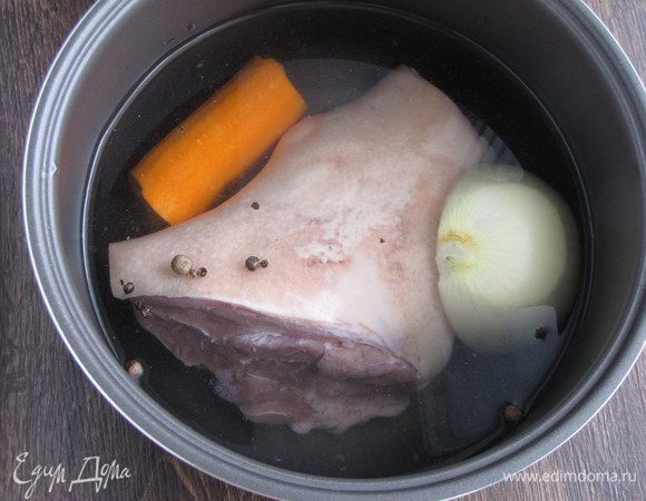 Свиную рульку хорошо вымыть, положить в чашу мультиварки, добавить холодную воду, чтобы закрыть мясо. Положить лук, морковь, перец горошком и душистый перец, посолить. 