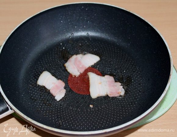 На разогретую сковороду кладем тонко нарезанную грудинку. Обжариваем ее с двух сторон. 