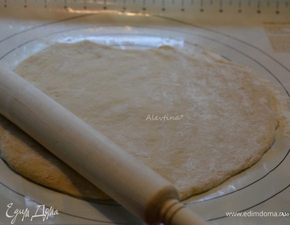 На припыленную мукой поверхность выложить тесто. Раскатать не тонко. Я делала два варианта пончиков пышных и раскатанных меньше 1 см.