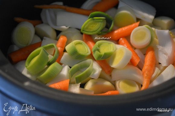 Выложить картофель на дно медленноварки. Затем лук крупно порезанный, лук-порей белая часть, морковь.
