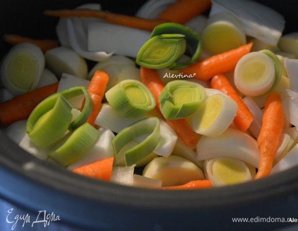 Выложить картофель на дно медленноварки. Затем лук крупно порезанный, лук-порей белая часть, морковь.