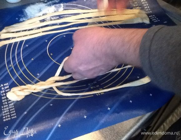 По контуру бабочку смазываем желтком. Прикрепляем украшения, в центре косичка из 4 жгутов, я долго не могла понять, как ее сплести и тут тоже помог муж, на фото его руки.