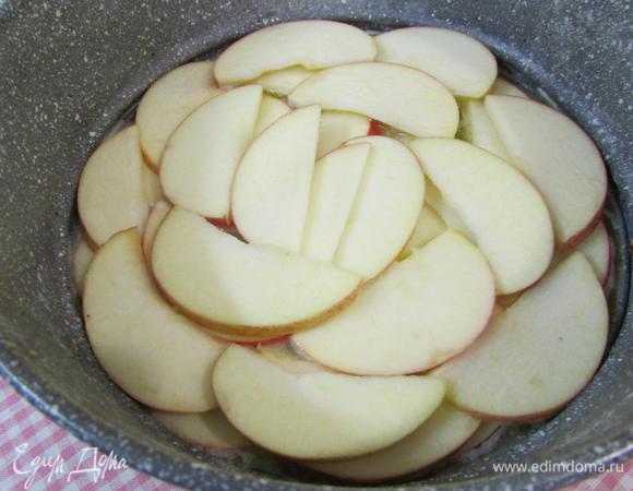 В масло выложить яблоки, нарезанные пластинами.