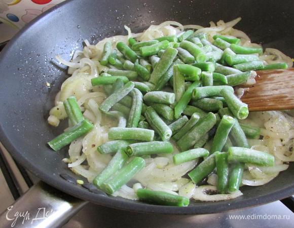 К луку выложить стручковую фасоль, перемешать, накрыть крышкой и тушить до готовности.