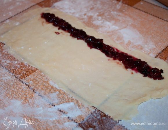 После охлаждения, раскатываем тесто «удлиненным прямоугольником» и по краю помещаем варенье.