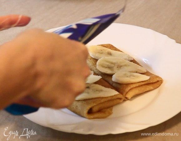 Сверху блинчика выкладываем нарезанные бананы и поливаем сгущённым молоком.