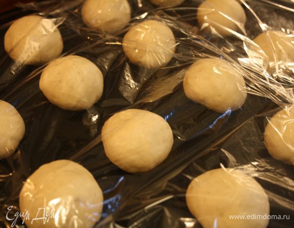 Сформировать круглые булочки, каждая примерно по 40 г (оригинальные делают по 80). Накрыть пленкой и оставить на расстойку на 50-60 минут, пока булочки не увеличатся в два раза. Важно не время, а размер. Если они будут меньше, то получатся жесткими, если больше, то могут опасть. Так что как увеличатся в два раза — пора выпекать.