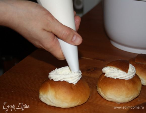 Взбить сливки с парой ложек сахарной пудры. При помощи кондитерского мешка и насадки звёздочка наполнить булочки и сделать "венок" из сливок. Сверху накрыть крышечкой.