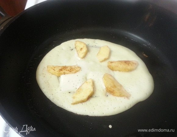 Разогреем сковороду, смажем растительным маслом. Выложим немного теста, распределив тонким слоем по сковородке. Сверху положим яблоки и зальем еще небольшим количеством теста. Накроем крышкой. Как только тесто схватится (около 1 минуты), перевернем блин и поджарим его с другой стороны.