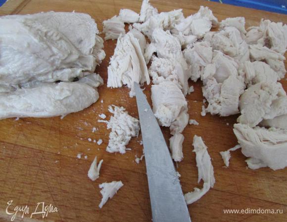 Заранее отварить куриное филе. Затем нарезать его небольшими кусочками.