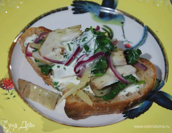 Обжаренный хлеб смазать заправкой, выложить артишоки со шпинатом и сыром, сверху еще немного полить заправкой.