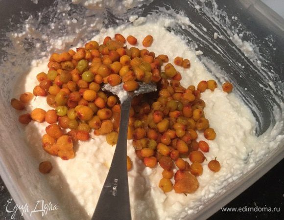 Предварительно размороженную облепиху аккуратно подмешайте к творожной массе.