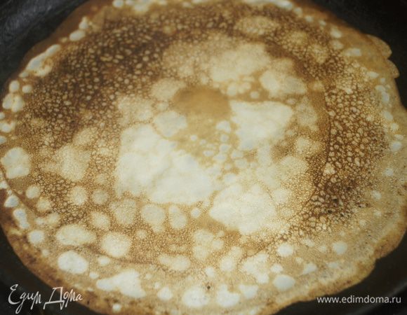 Выпечь тоненькие блинчики на хорошо разогретой сковороде, смазанной тонким слоем растительного масла.