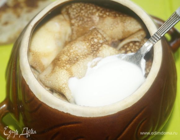 Выкладываем нафаршированные блинчики в смазанные сливочным маслом горшочки, каждый слой промазываем сметанной заливкой. Верх тоже смазываем сметаной. Накрываем крышечкой и ставим в разогретую до 150°C духовку, томиться на 1 час.