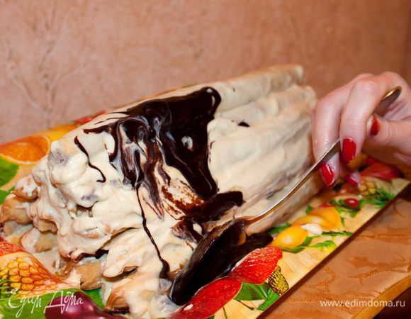 Заливка торта глазурью.
Шоколадная глазурь, стекая, растапливает крем. Мы аккуратно столовой ложкой, как-бы поднимая глазурь, снова и снова заливаем «крышу избы».
Так получается рисунок легкой чешуйки.