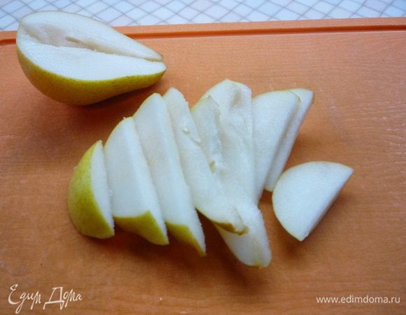 Грушу разрезаем пополам, удаляем сердцевину и нарезаем тонкими дольками.