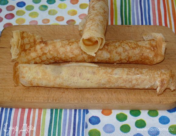 Готовые блины обильно смазываем сливками с обеих сторон (я использую деревенские домашние). Сворачиваем в трубочки, оставив средину полой. Отправляем в холодильник на 20 минут, пока сливки не застынут полностью и  блинные трубочки станут твердыми.