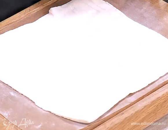 Рабочую поверхность присыпать мукой, раскатать тесто в прямоугольник и выложить на бумагу для выпечки.