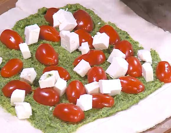 Внутренний прямоугольник смазать тонким слоем соуса песто, выложить половинки помидоров, а сверху фету.