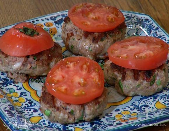 Помидор нарезать кружками и разложить на горячие котлеты.