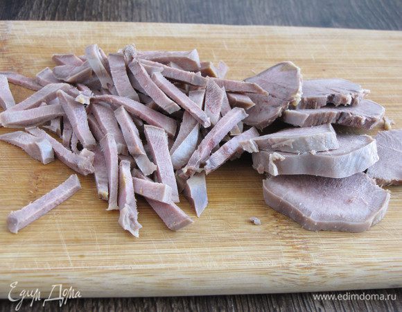Отварной язык почистите и нарежьте тонкой соломкой.