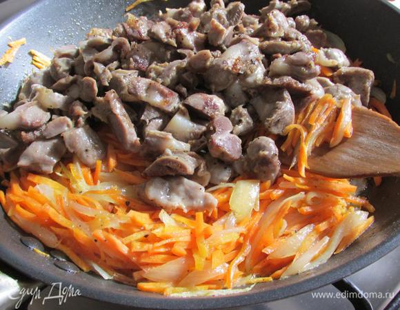 К овощам добавить желудки, немного бульона, накрыть крышкой и тушить на среднем огне, примерно 10 минут.