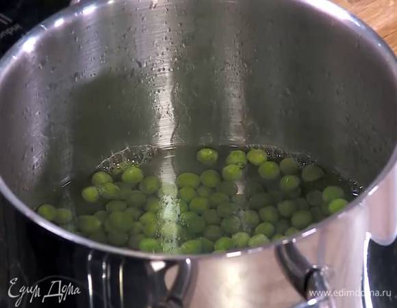 Зеленый горошек разморозить, затем опустить на пару минут в кипящую воду, затем откинуть на сито и обдать ледяной водой.