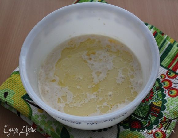 Затем влить оставшееся молоко, добавить сахар, соль, желток, масло и хорошо размешать.