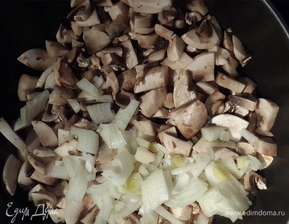 Тесто разморозить. Грибы и лук порезать. Обжарить на сковороде в растительном масле до полуготовности, чтобы выпарилась вода.