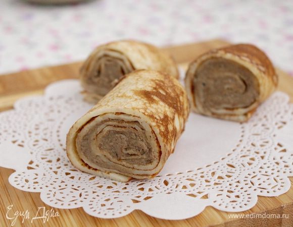 Достать блины из холодильника и острым ножом разрезать на порции по 2,5–3 см. Выложить рулетики, добавить сверху каждого кусочка немного брусничного соуса.