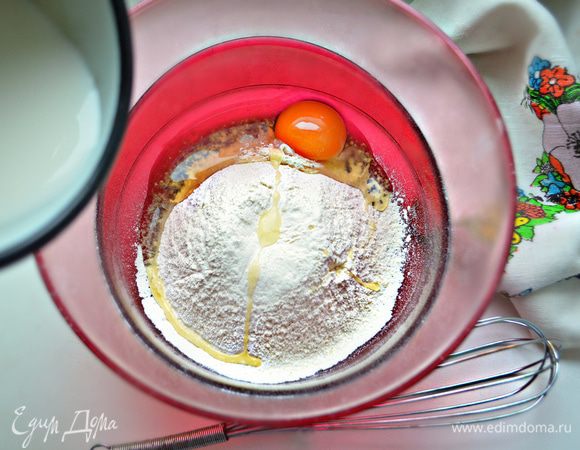 Вбить 1 яйцо, всыпать 140 г просеянной муки, 0,5 ч. л. сахара и постепенно добавить 300 мл молока.