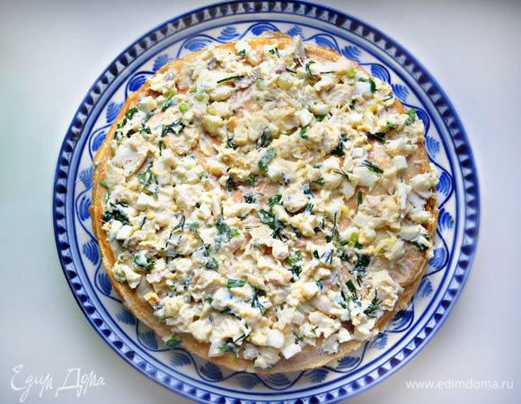 В керамическое блюдо или форму выложите 1 блин и сверху равномерно распределите начинку. Сверху накройте другим блином и снова начинку. Продолжайте таким образом выкладывать слоями блины и начинку. Последним накройте блином и смажьте сливочным маслом. Запекайте пирог в разогретой до 200°С духовке 15 минут. Можно запечь и в микроволновой печи.