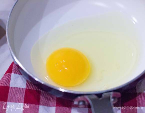 На оставшемся оливковым маслом приготовьте глазунью из двух яиц так, чтобы желтки оставались чуть жидковатыми. В конце приготовления посолите и поперчите.