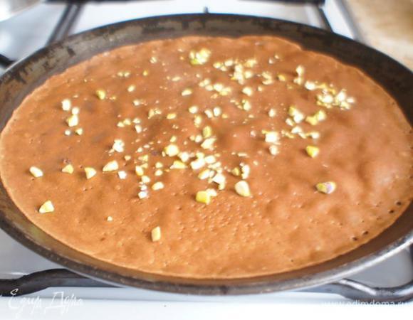 Сковороду для блинов разогреть. Перед выпечкой первого блинчика смазать ее растительным маслом (без запаха). Влить половником тесто и сразу же посыпать рубленными фисташками. Через секунд 20-30 перевернуть.