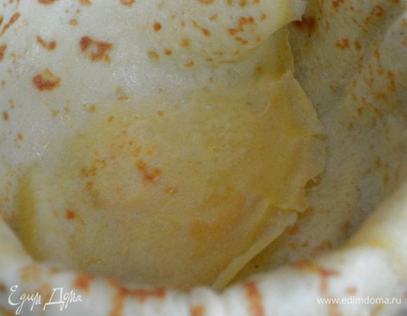 Собираем наш пирог: взять разъемную форму диаметром 18-20 см. Дно смазать маслом, бока застелить пекарской бумагой. Застелить блины внахлест друг на друга, чтобы края свисали.