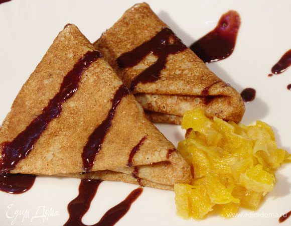 Выкладываем ореховые блинчики на тарелку с апельсинами, поливаем шоколадным соусом.