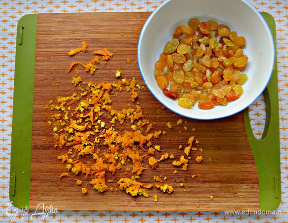 В это время замочить 2 ст. л. изюма в тёплой воде на 10 минут, затем воду слить. Натереть цедру апельсина.