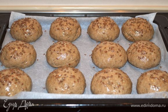 Наши булочки подошли. Взбиваем яйцо, смазываем верх и посыпаем льняными семечками верх хлебушков. Ставим в разогретую до 180°C духовку на 20-25 мин.