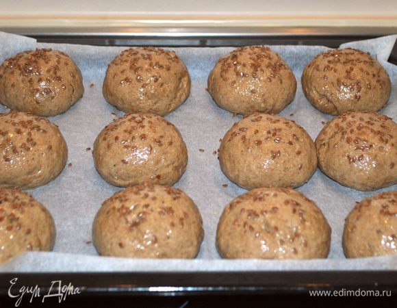 Наши булочки подошли. Взбиваем яйцо, смазываем верх и посыпаем льняными семечками верх хлебушков.
Ставим в разогретую до 180°C духовку на 20-25 мин.