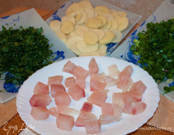 Филе рыбы вымыть, обсушить и нарезать на небольшие кубики.
Зеленый лук, укроп, петрушку вымыть и мелко нарезать.
Картофель вымыть, очистить и нарезать тонкими кружочками.