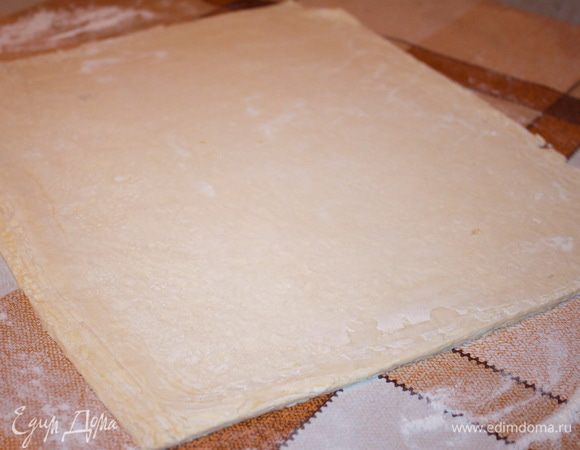 Слоенное тесто разморозить при комнатной температуре и раскатать толщиной 5 мм. Должен получиться прямоугольник 30х40 сантиметров, лишнее тесто обрезать и отложить в сторону.