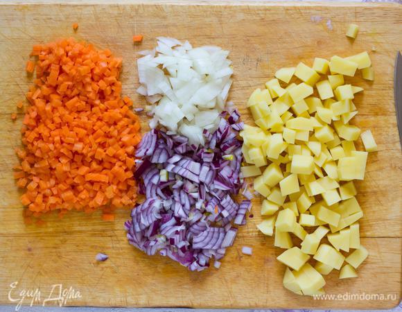Лук, морковь и картофель, очистите. Лук нашинкуйте, морковь мелко нарежьте, картофель порежьте на кубики.