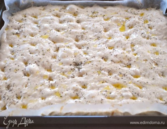 Через час сбрызгиваем оливковым маслом. Пальцами делаем углубления. Посыпаем морской солью и прованскими травами. И только теперь включаем духовку на 180°C, после того, как она нагрелась, отправляем в нее противень на 25-30 минут.