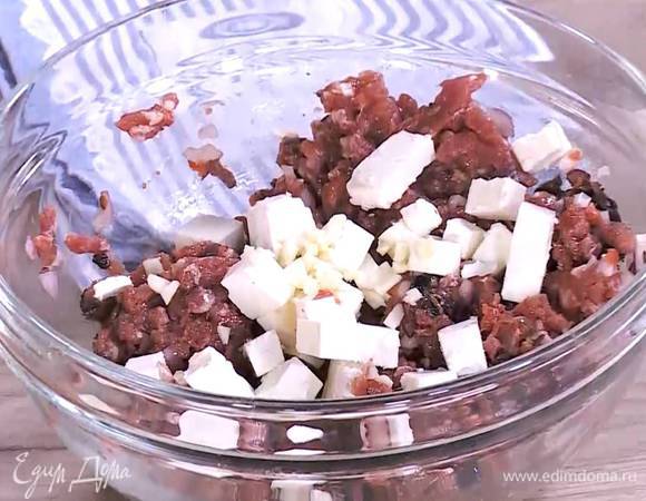 Фарш соединить с нарезанными оливками, шалотом и томатной пастой, посолить, поперчить, посыпать кумином, влить 1‒2 ч. ложки оливкового масла Extra Virgin, все перемешать, затем добавить фету и измельченный чеснок, еще раз все вымешать и дать фаршу постоять.